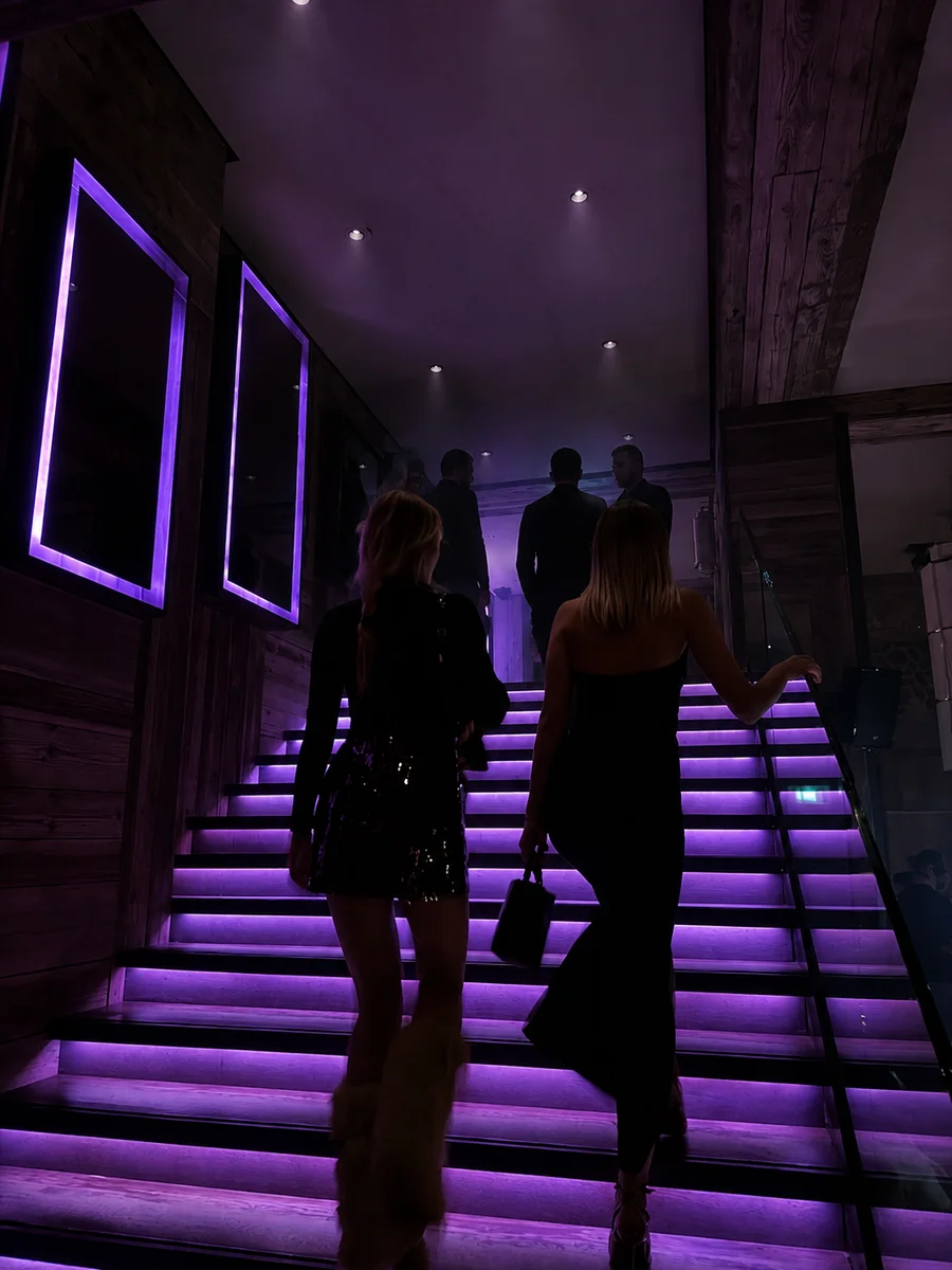 Pareja subiendo una escalera iluminada en púrpura — el camino de acceso al universo Spicy