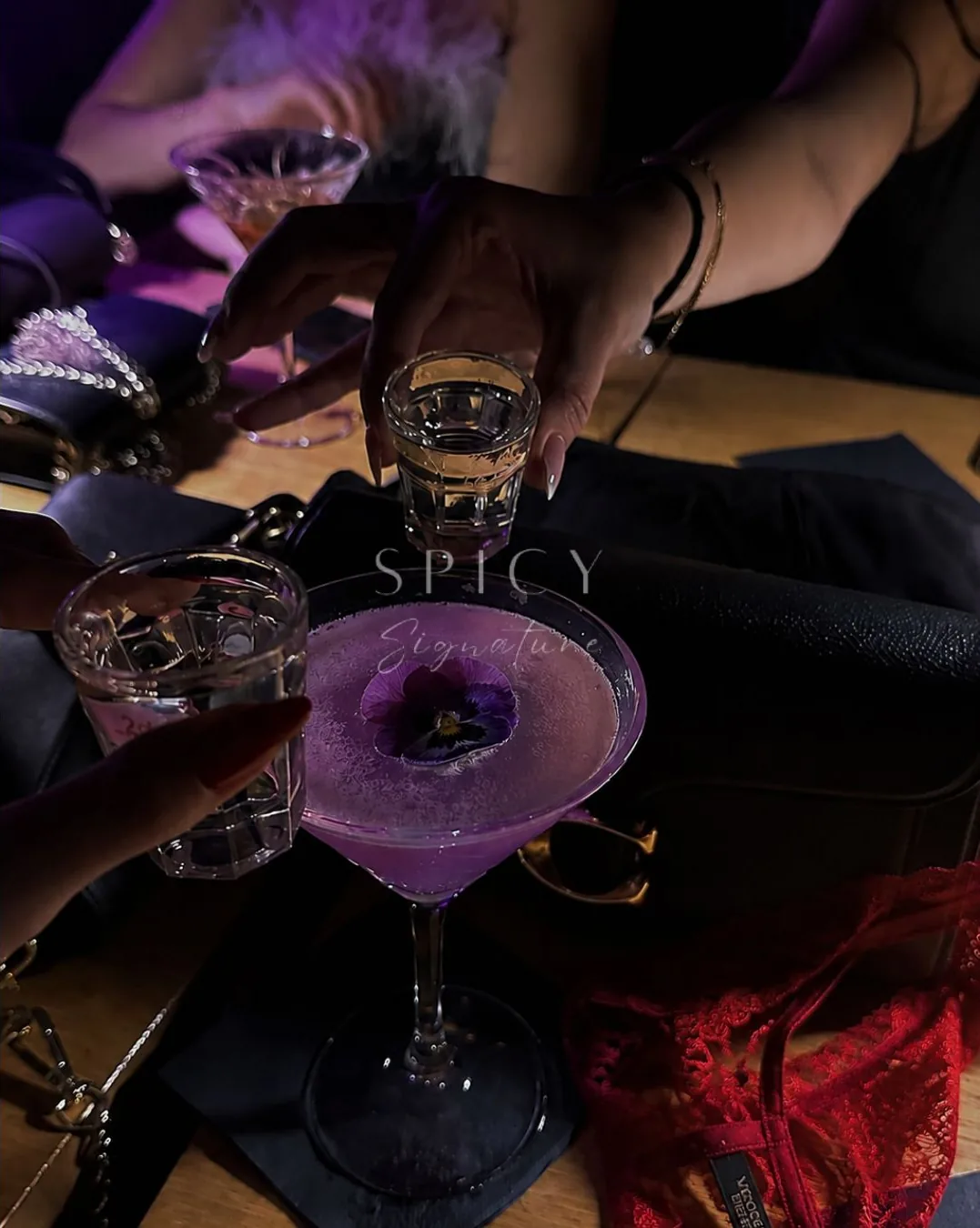 Brindis con un cóctel de autor coronado con una flor, en una noche Spicy en Bogotá