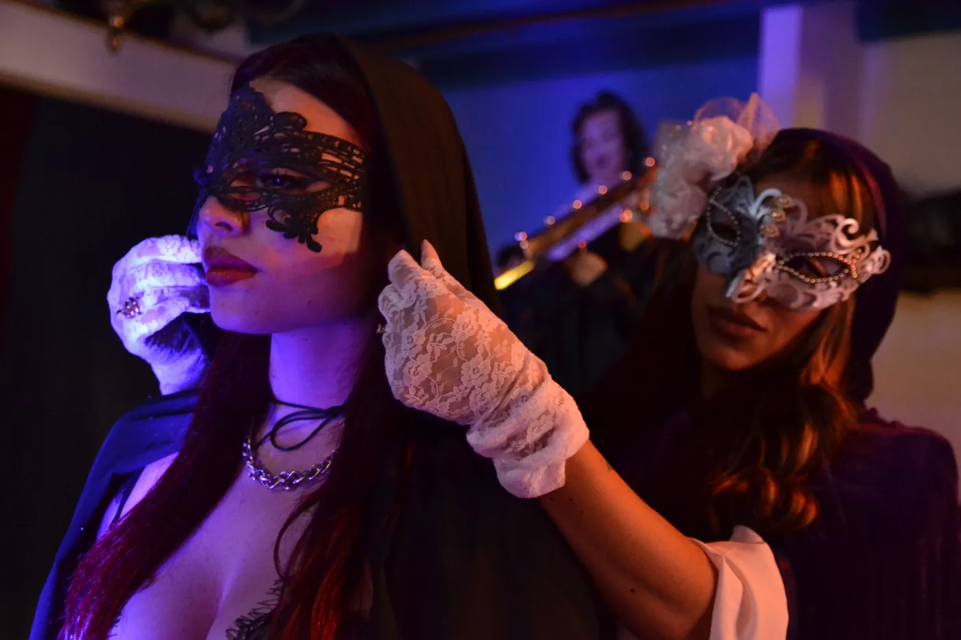 Dos invitadas con máscaras de encaje durante una noche Masquerade
