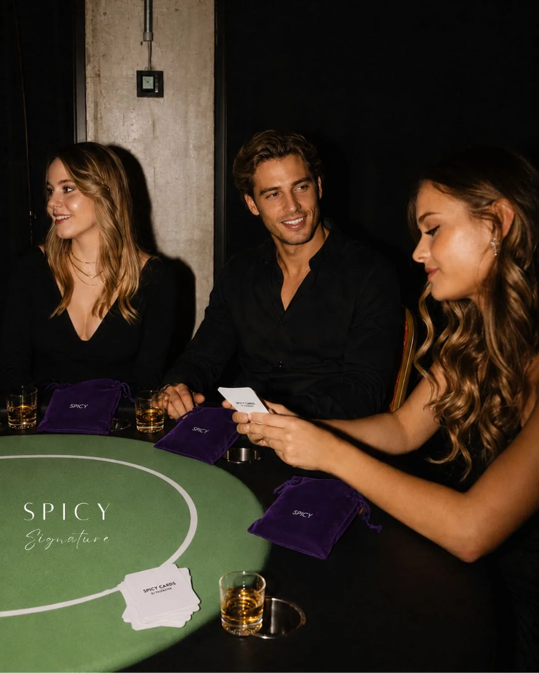 Tres invitados juegan cartas en una mesa de la Fiesta Spicy