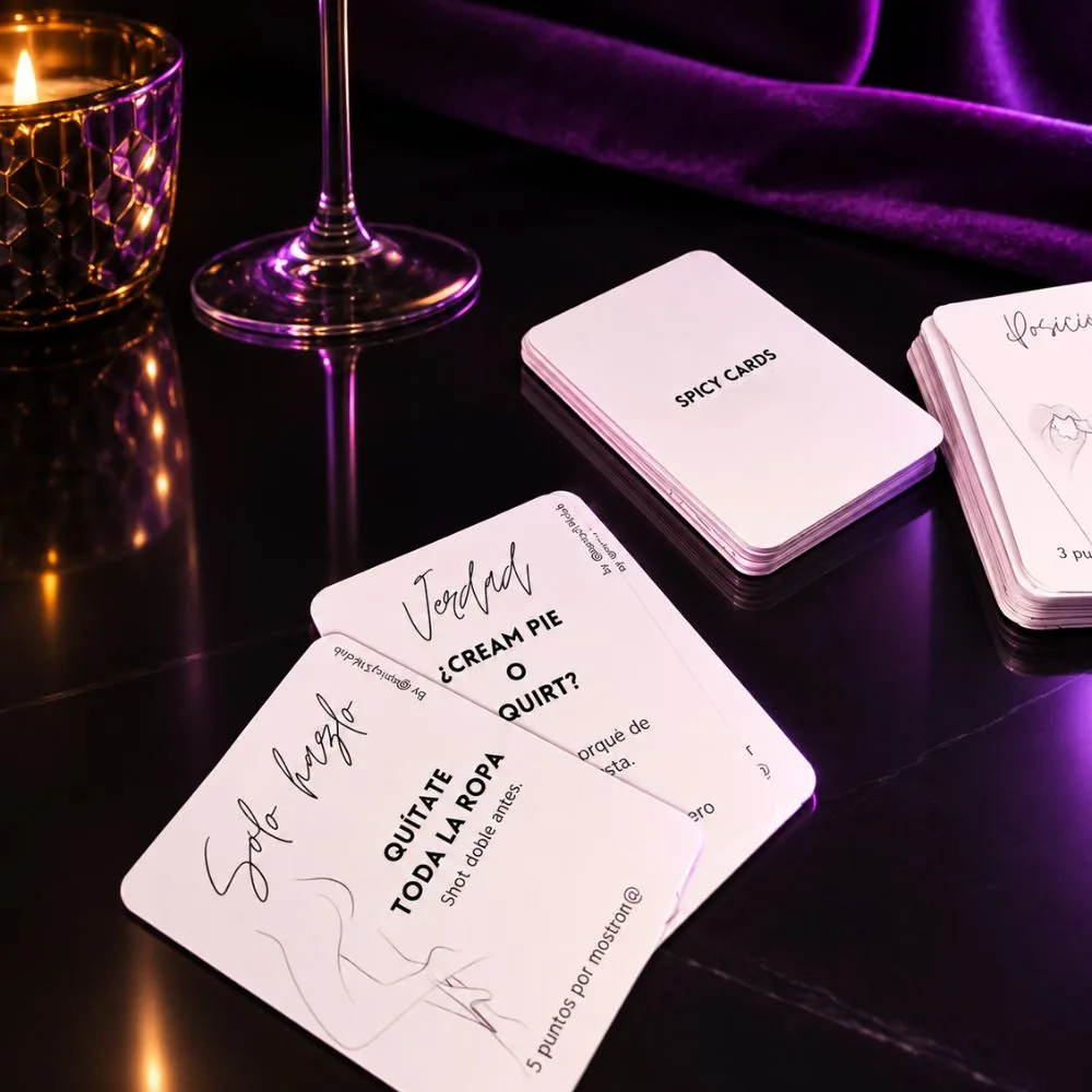 Baraja de Spicy Cards sobre una mesa, junto a una copa y una vela