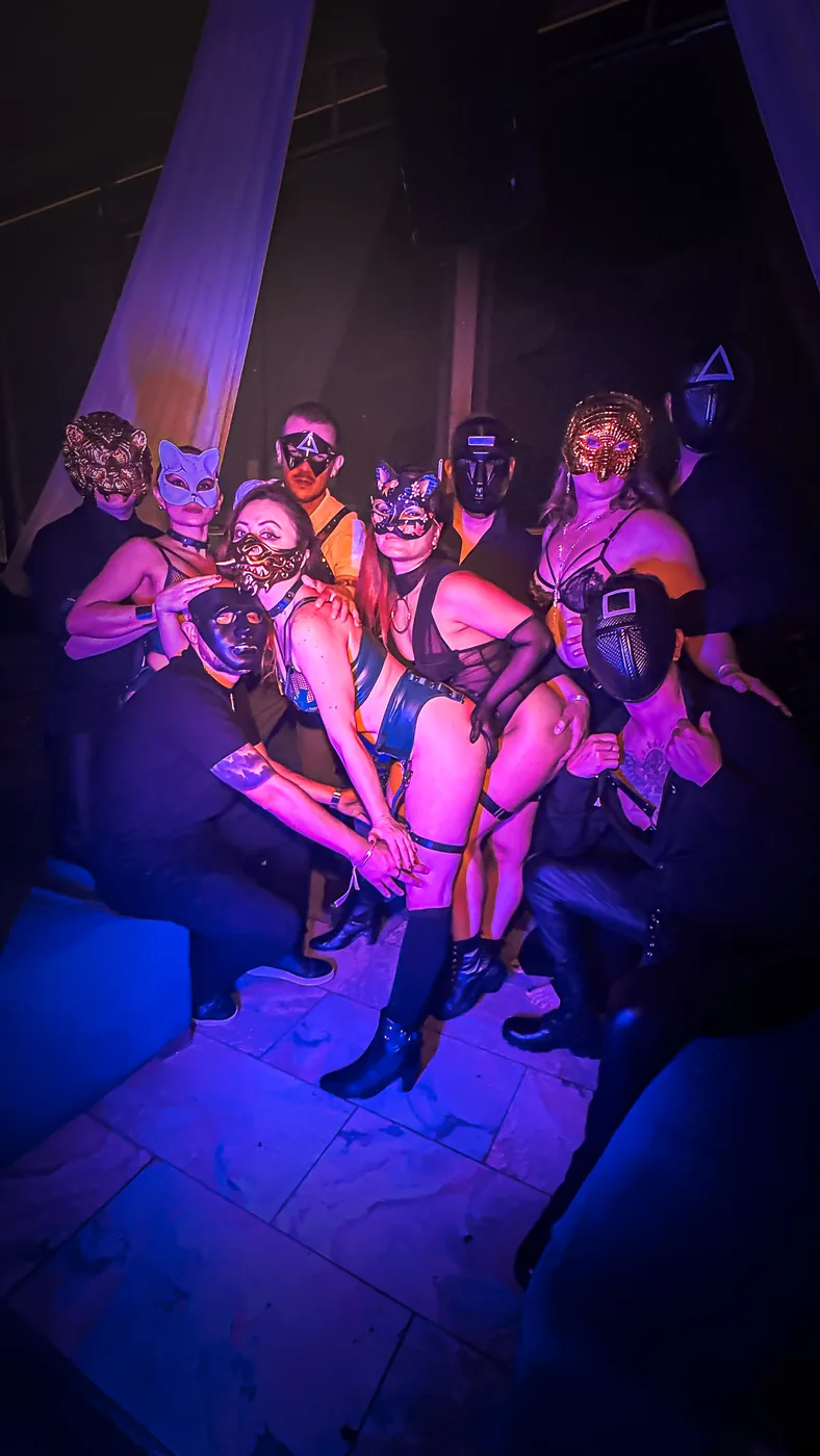 Grupo de invitados con máscaras posa durante una Fiesta Spicy